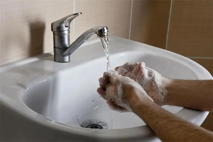 Handwashing under running water to illustrate hygiene and cleaning for daily wear devices