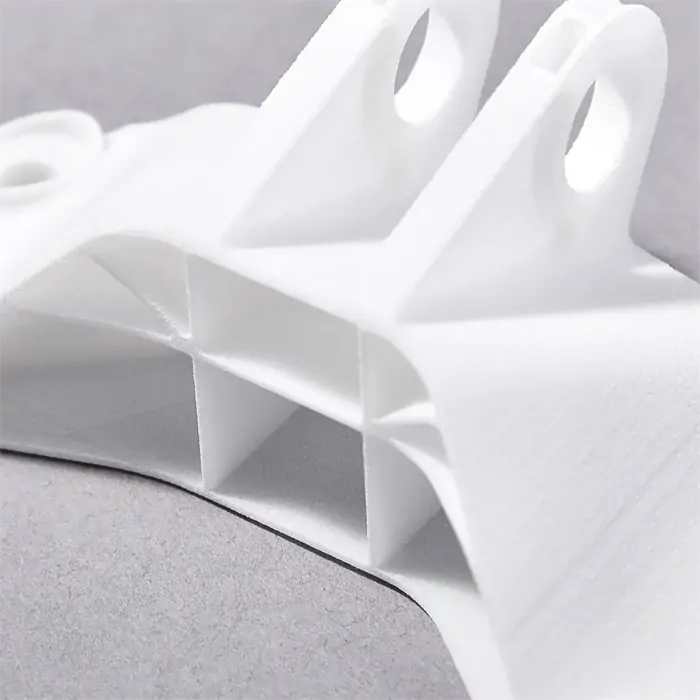 White PA12 nylon 3D printed part showing lightweight structure and smooth rounded edges